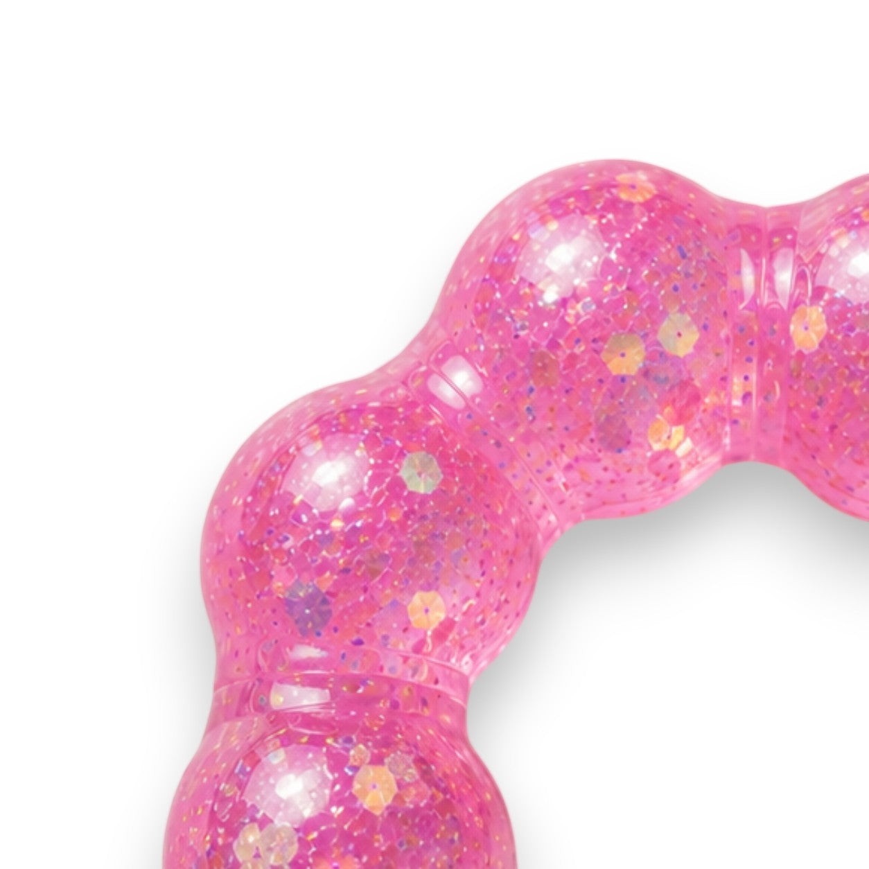 Mellow Monkey Bubblegum Glow Feelzies sensory bracelet in translucent pink with glitter on a marble surface.
