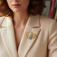 Mellow Monkey Bumble Bee Fashion champagne rhinestone brooch pin with gold-tone body and black enamel stripes on a cream blazer.