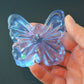 Mellow Monkey butterfly-shaped jelly squishy in translucent blue with glittery star and heart accents held in hand