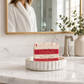 Mellow Monkey Candy Cane Christmas vegan handmade bar soap with red and white stripes on a white ceramic soap dish.
