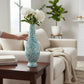 Mellow Monkey 26-inch tall bottleneck vase featuring a blue and white iridescent capiz shell mosaic on a wooden table