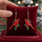 Mellow Monkey handmade cardinal earrings with surgical steel wires, featuring red birds on holly branches.