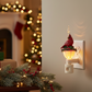 Mellow Monkey cardinal night light plugged into a wall with a festive holiday living room background