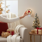Mellow Monkey resin cardinal night light plugged into a wall, creating a cozy holiday atmosphere in a living room.