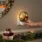 Mellow Monkey Woodland Noel Cardinals LED night light featuring a festive wreath design plugged into a wall outlet.