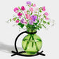 Mellow Monkey Casablanca lime green recycled glass mini vase suspended in a black metal stand with sweet pea flowers.