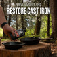 Mellow Monkey Cast Iron Oil 8-oz bottle being held over cast iron pans on a tree stump in a forest setting.