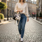 Mellow Monkey 2-piece black and white cat shoulder bag set with top handles and adjustable strap on a woman walking.