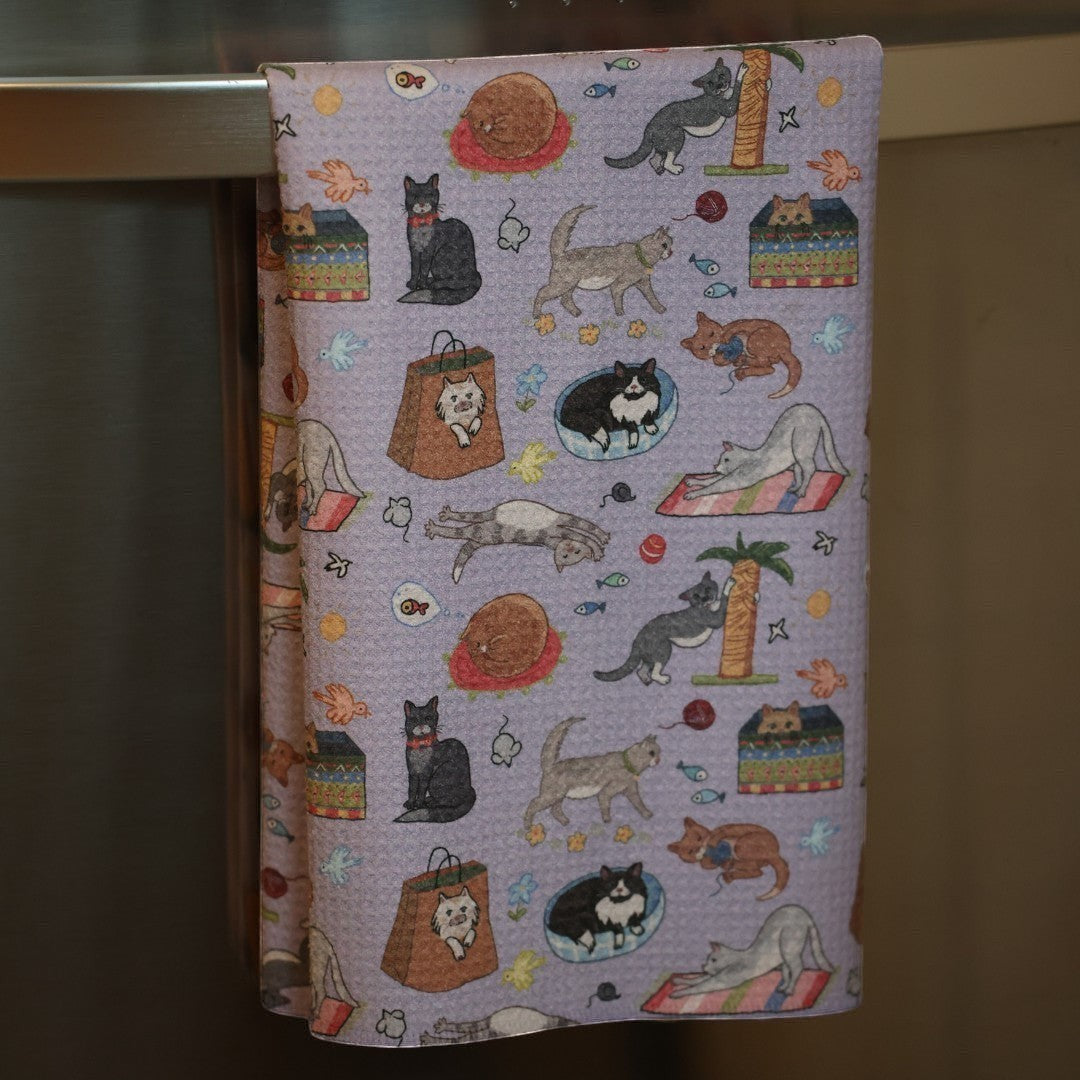 Mellow Monkey light purple waffle dish towel with cute cat illustrations, yarn, fish, mice, and birds.