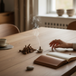 Mellow Monkey cedar scented incense cones with ceramic holder on a wooden table with a hand and open book nearby