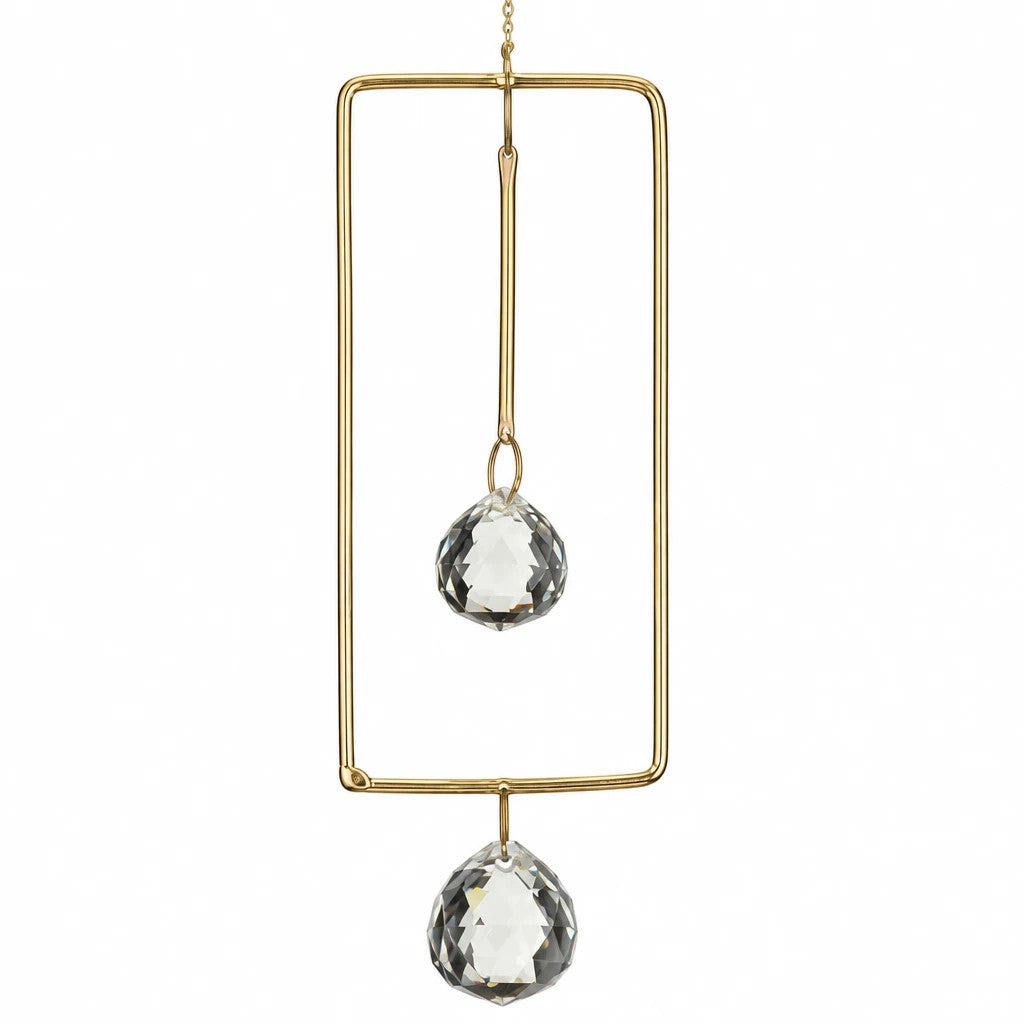 Mellow Monkey celestial suncatcher featuring a rectangular bronze frame with two hanging faceted clear crystals
