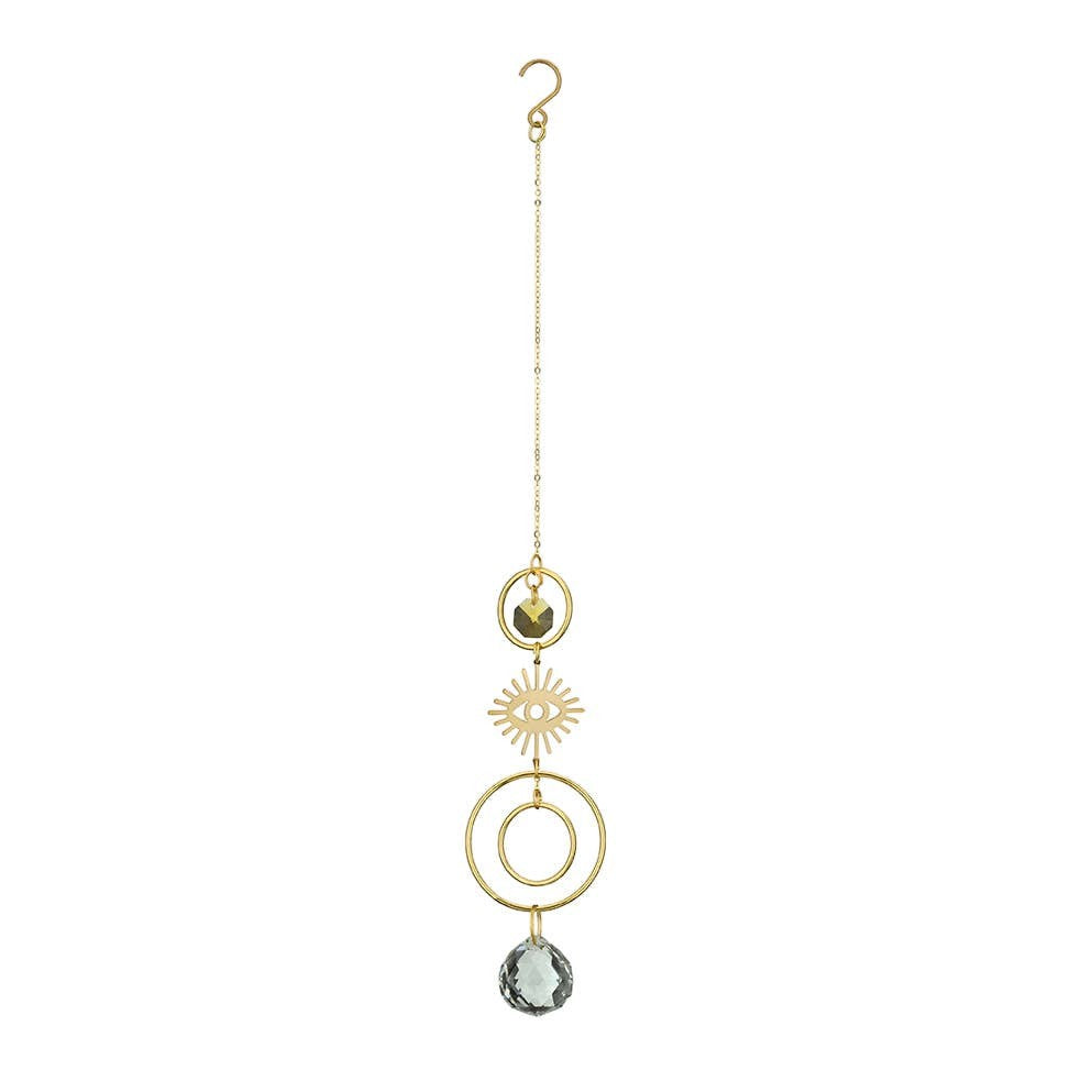 Mellow Monkey celestial eye suncatcher with gold chains, bronze wire, and hanging crystals for window decor.