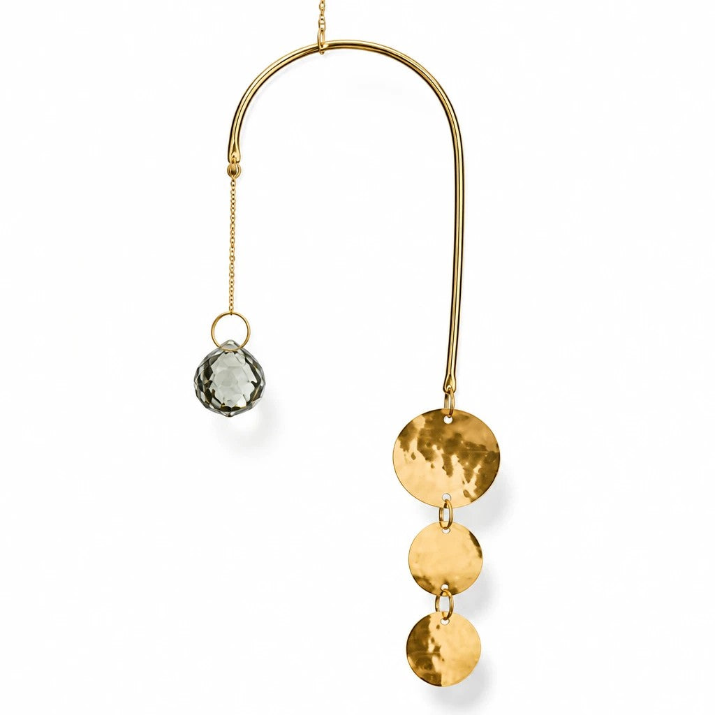 Mellow Monkey celestial suncatcher with a bronze wire frame, gold chain, faceted crystal, and hanging metallic discs.