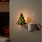 Mellow Monkey vintage-style ceramic Christmas tree nightlight with colorful bulbs glowing on a wall near a cozy chair.