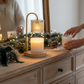 Mellow Monkey champagne crystal candle warmer lamp with gold stem and wooden base on a festive holiday mantelpiece.