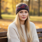 Mellow Monkey charcoal wool headband with floral embroidery worn by a woman in an autumn park setting.