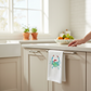 Mellow Monkey white cotton flour sack towel featuring a watercolor Santa Clawdia crab wearing a festive Santa hat.
