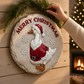 Mellow Monkey Christmas goose wall plaque featuring a Santa-dressed goose on a stone-look resin disc with snowflakes.