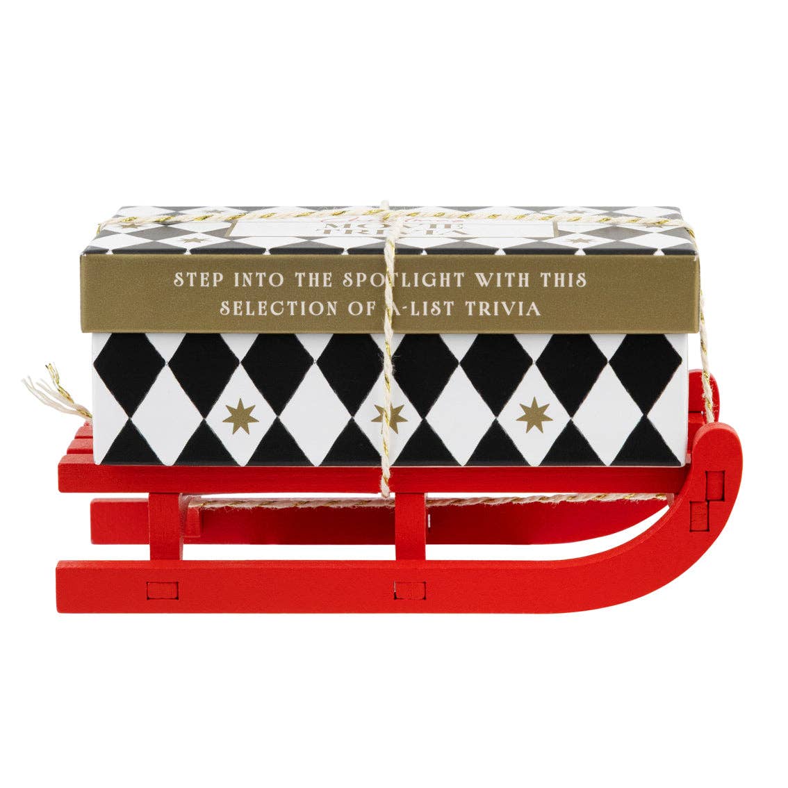 Mellow Monkey Christmas movie trivia game in a black and white diamond patterned box on a small red wooden sleigh.