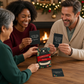 Mellow Monkey Christmas Trivia game box and question cards held by a group of friends at a festive dinner table.