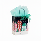 Mellow Monkey medium Christmas Village gift bag with glossy winter town print, paper handles, and tissue paper.