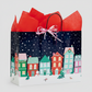 Mellow Monkey large Christmas Village gift bag with glossy winter town print, red tissue paper, and paper handles.