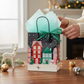 Mellow Monkey medium Christmas Village gift bag with glossy print, twisted handles, and included tissue paper.
