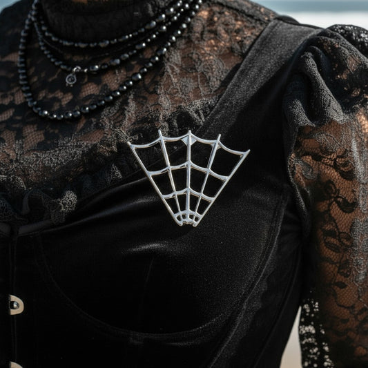 Mellow Monkey chrome spider web pin pinned to a black velvet gothic top with lace details.