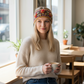 Mellow Monkey cinnamon wool headband with floral embroidery worn by a blonde woman holding a coffee in a cafe