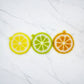 Mellow Monkey Citrus Squeeze Scrubby set of three handmade round dish scrubbers in lemon, lime, and orange designs.