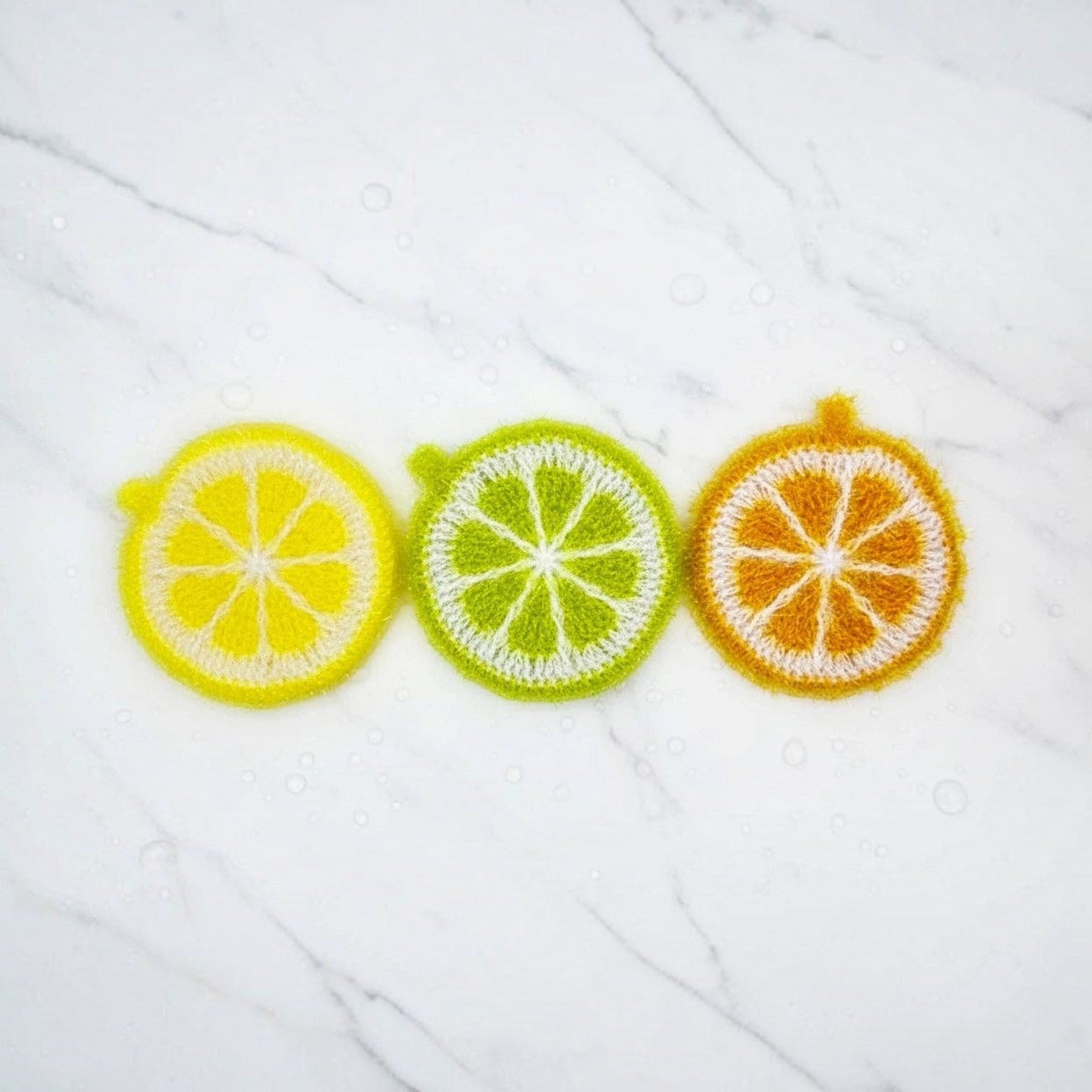 Mellow Monkey Citrus Squeeze Scrubby set of three handmade round dish scrubbers in lemon, lime, and orange designs.