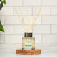 Mellow Monkey Pet House reed diffuser in Fresh Citrus scent with orange and lemon pattern on a wooden coaster