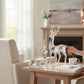 Mellow Monkey clear sculpted acrylic deer figurines in sitting and standing poses on a wooden table in a living room