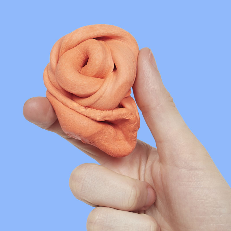 Mellow Monkey Speks Blur focus putty in clementine orange being stretched and squeezed by hand