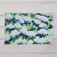 Mellow Monkey Coastal Hydrangea reversible woven cotton placemat with blue and white floral art on a wood table.