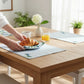 Mellow Monkey Coastal Hydrangea reversible cotton placemats on a wooden dining table with a croissant plate