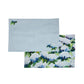 Mellow Monkey coastal hydrangea reversible woven cotton placemat in light blue with floral artwork on a wooden table