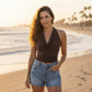 Mellow Monkey coffee brown halter neck tank top with a draped cowl neckline worn by a woman on a sunny beach.
