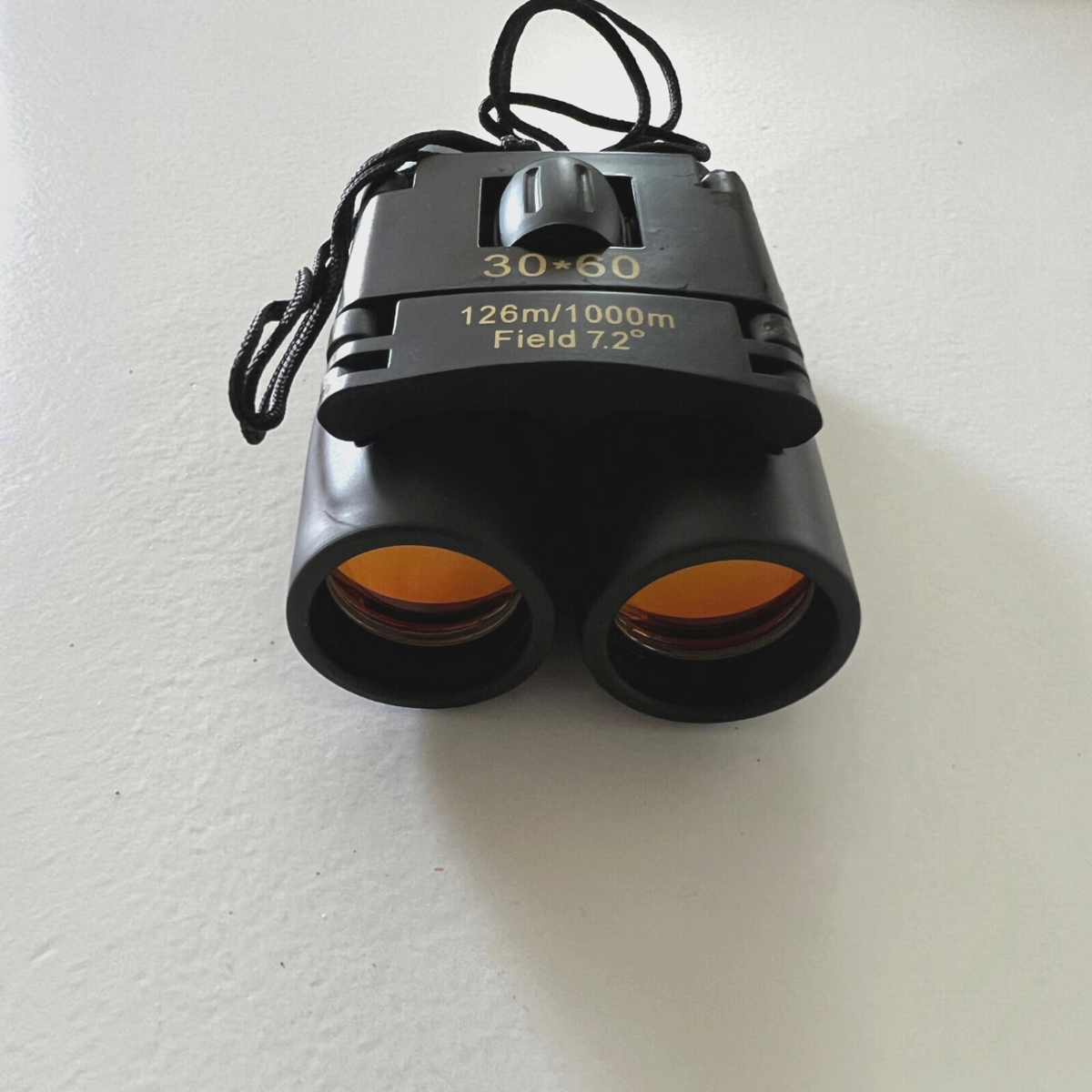 Mellow Monkey 30x60 compact folding roof prism binoculars with orange-tinted lenses for outdoor travel and hunting.