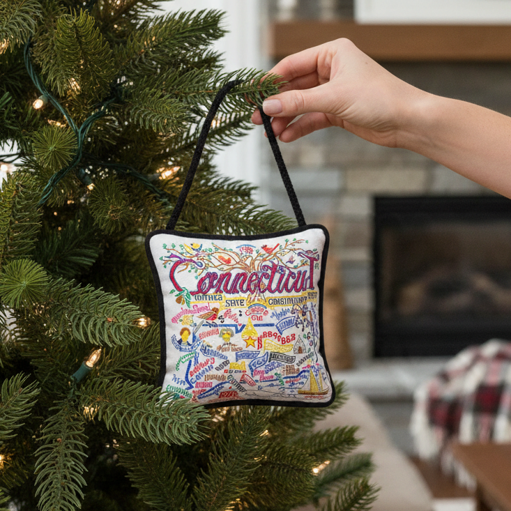 Mellow Monkey Connecticut mini pillow ornament with hand-embroidered state landmarks hanging on a Christmas tree.