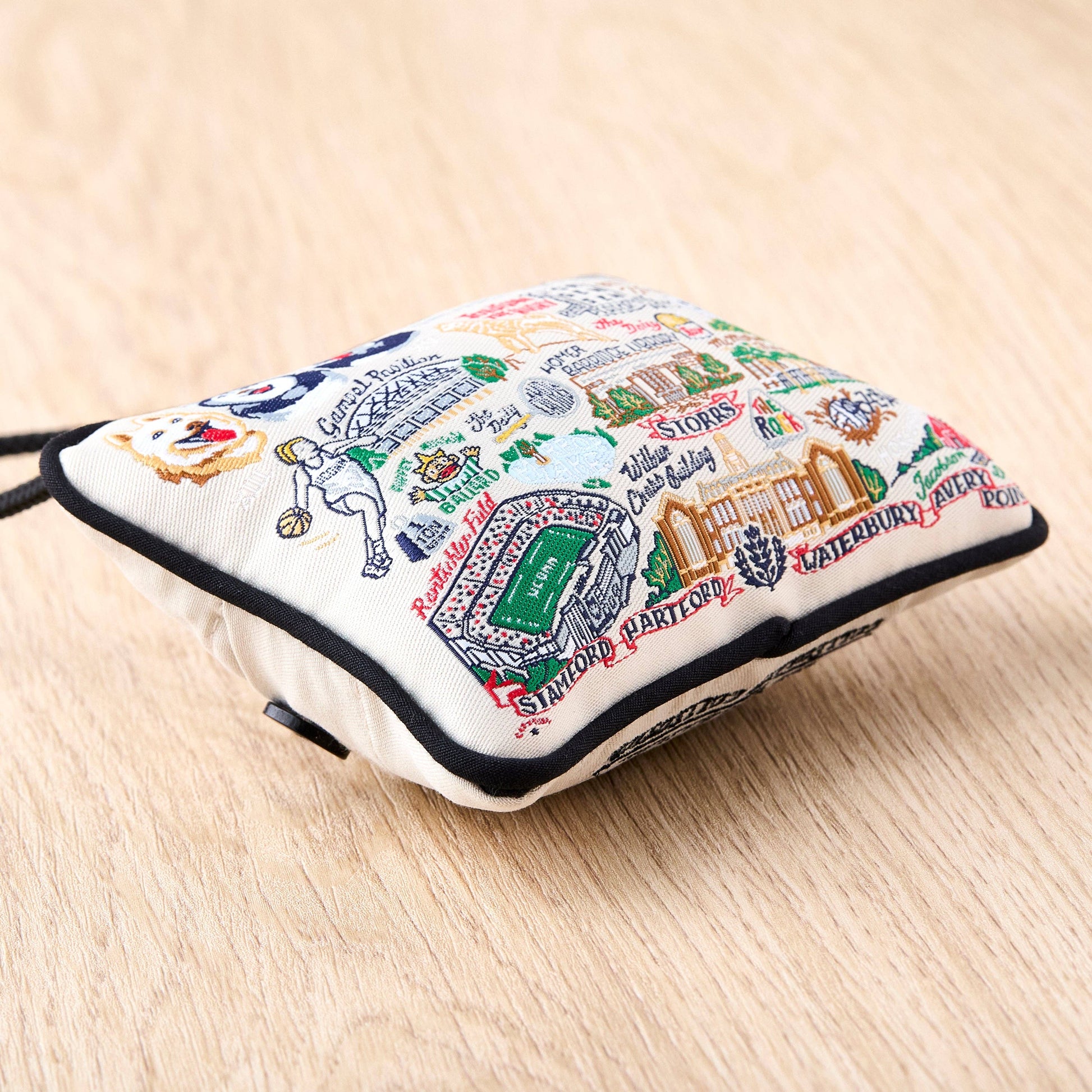 Mellow Monkey University of Connecticut woven mini pillow ornament featuring colorful campus landmarks and icons.