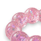 Mellow Monkey Cotton Candy Sparkle Feelzies sensory bracelet with pink glittery bubbles on a marble surface.