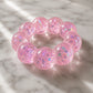 Mellow Monkey Cotton Candy Sparkle Feelzies sensory bracelet with pink glittery bubbles on a marble surface.
