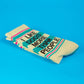 Mellow Monkey crew socks in cream with teal text reading I Like Dogs More Than People and pink striped accents.