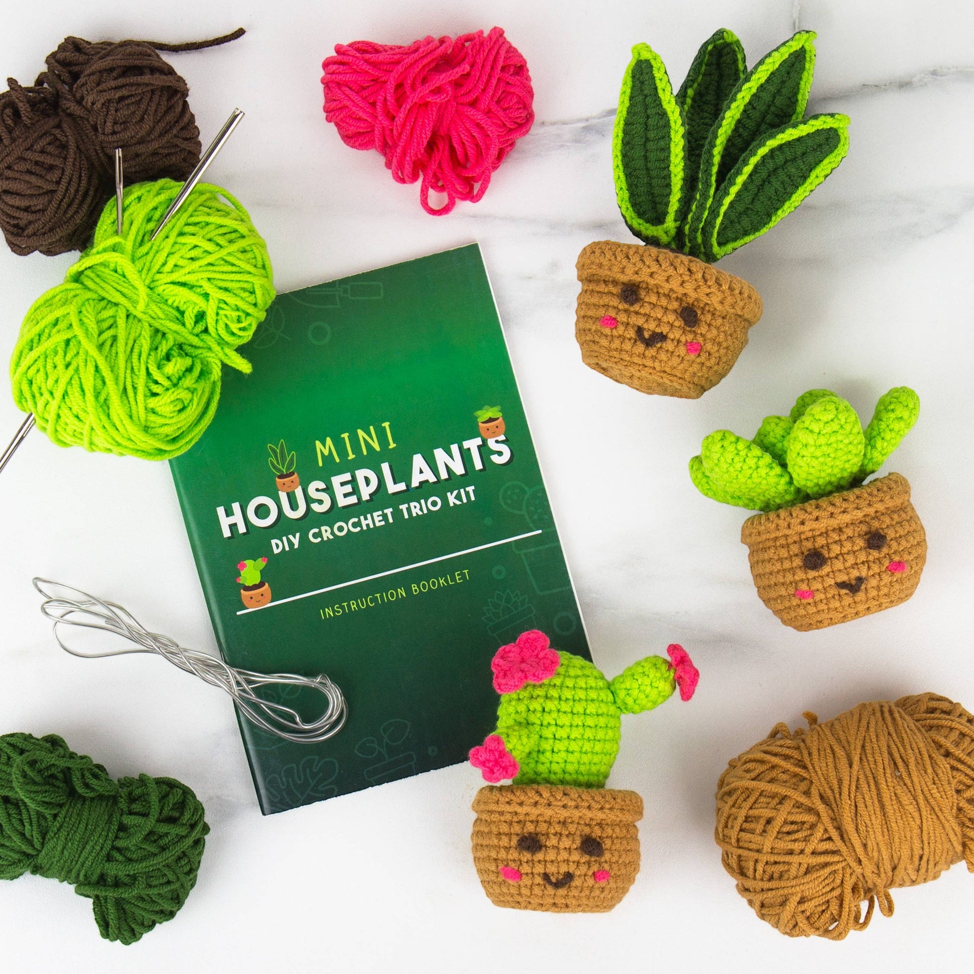 Mellow Monkey Pocket Crochet Mini Houseplants DIY kit with yarn, crochet hooks, instruction booklet, and three finished plush succulents.