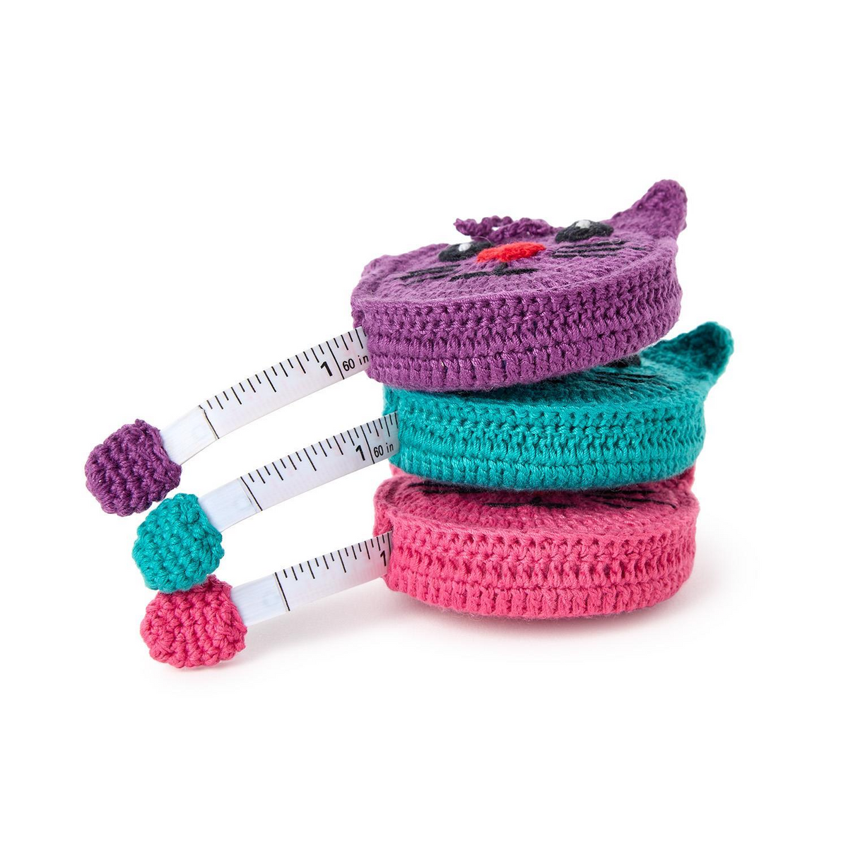 Mellow Monkey hand-crocheted kitty cat measuring tapes in pink, purple, and teal stacked on a white background.