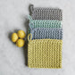 Mellow Monkey thick crocheted cotton pot holders in gray, mint green, blue, and yellow with hanging loops. 8-in square.