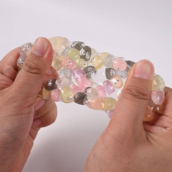 Mellow Monkey Crunch & Squish candy-themed stress ball being stretched to show the crunchy sensory filling inside.