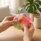 Mellow Monkey Crunch & Squish candy-themed stress ball with colorful, textured spheres held in hands for sensory play.