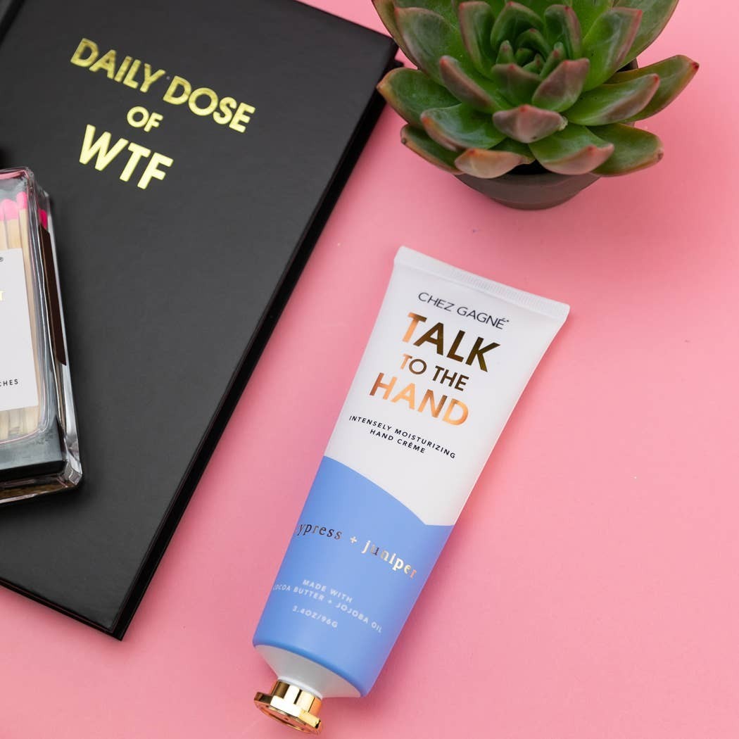 Mellow Monkey Talk to the Hand cypress and juniper scented hand cream in a white and blue tube with a gold cap.